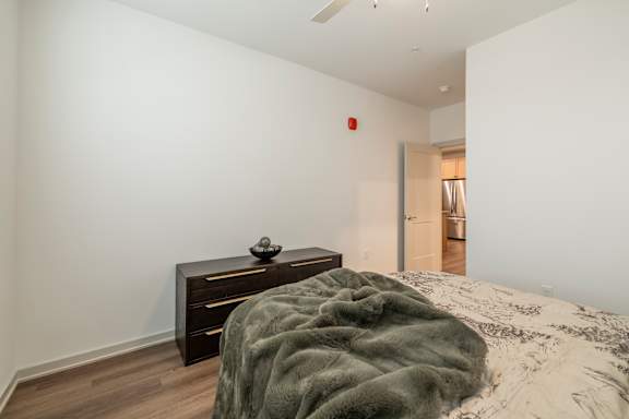 A bedroom with a bed, a nightstand and a door.