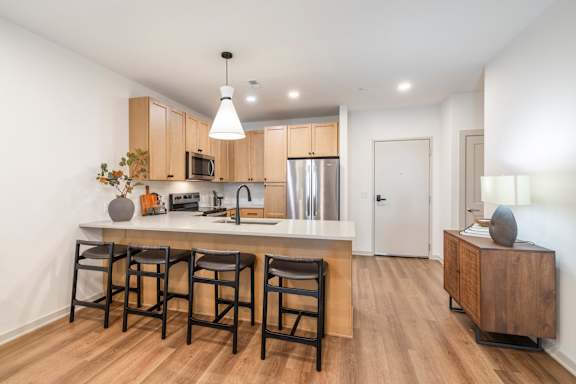 A kitchen with wooden floors and a white counter top.