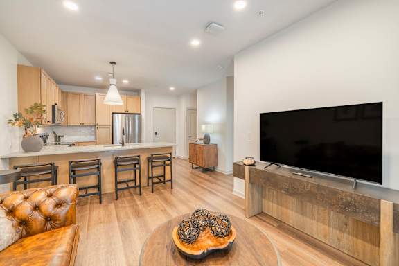 A modern living room with a brown leather couch and a wooden coffee table.