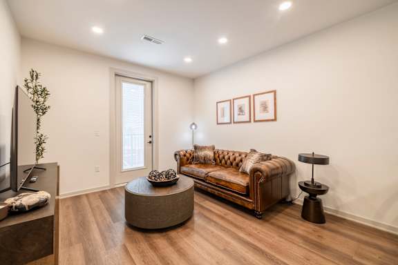 A living room with a brown couch and a wooden coffee table.
