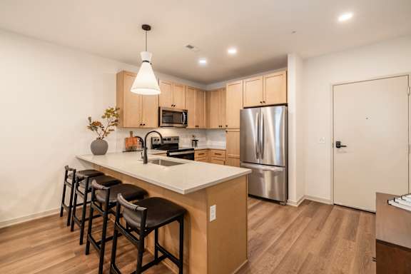 A kitchen with a white counter top and wooden cabinets.