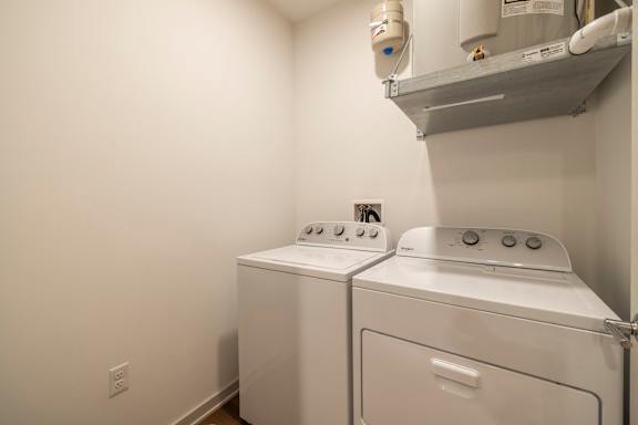 Two white front loading washing machines in a laundry room.