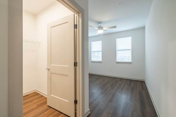 A room with a door and a ceiling fan.
