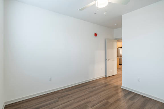 A room with a white wall and a wooden floor.