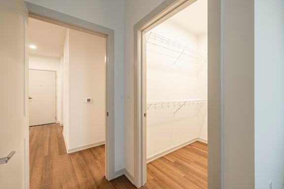 A hallway with a white door and a wooden floor.