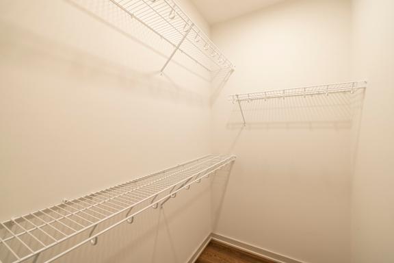 Empty wire shelving in a white room.