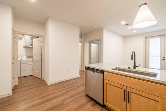 A kitchen with wooden floors and white walls.