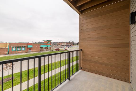 A balcony with a black railing and a view of a building.