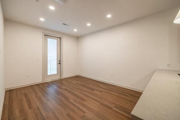 A room with wooden floors and a white door.