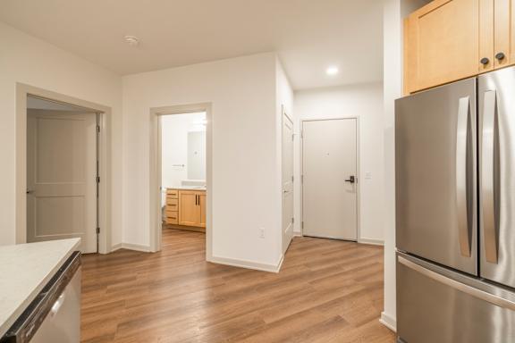 A kitchen with a refrigerator on the right side.