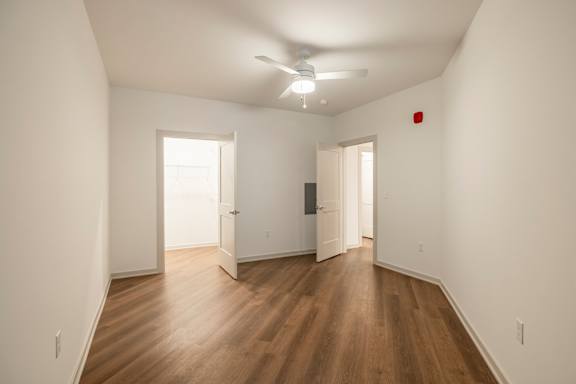 A room with wooden floors and a ceiling fan.
