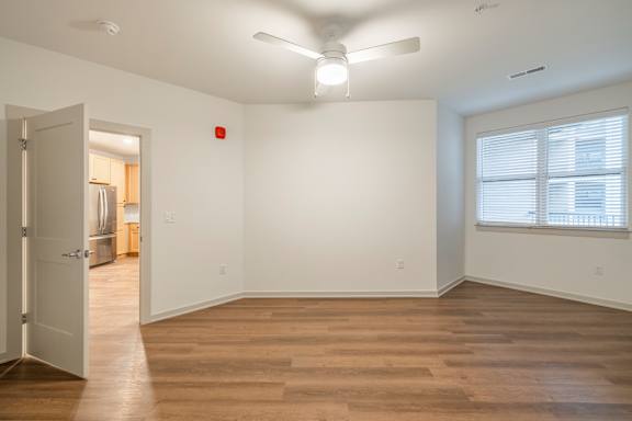 A room with a wooden floor and a ceiling fan.