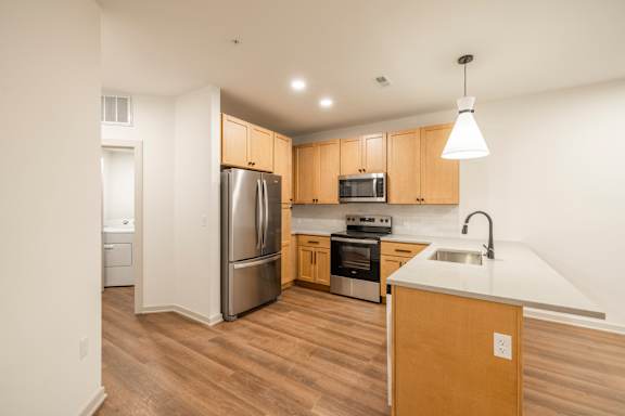 A kitchen with wooden cabinets and a white counter.