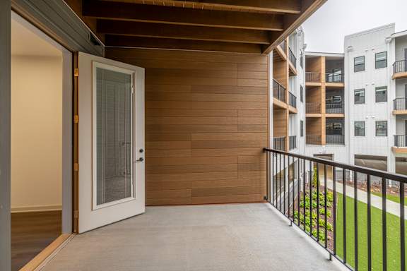 A balcony with a white door and a black railing.