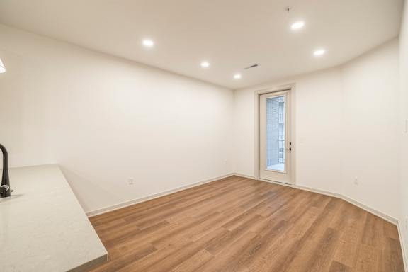 A room with wooden flooring and a white door.
