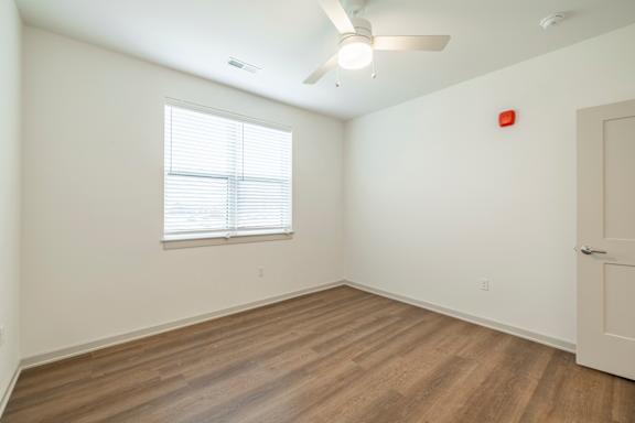 A room with a window and a ceiling fan.