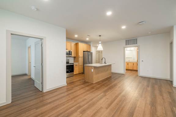 A kitchen with wooden floors and white walls.