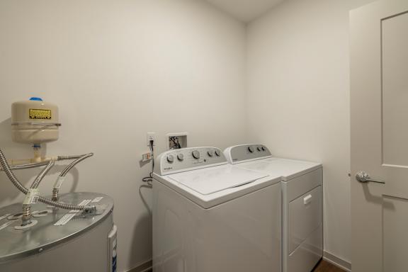 A washing machine is sitting in a small room.