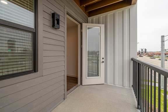 A grey house with a white door and a window.