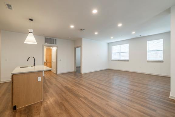 A large empty room with wooden floors and white walls.