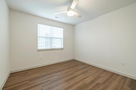 A room with a window and wooden flooring.