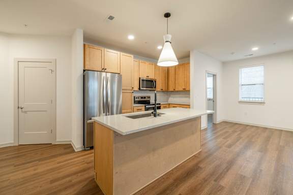 A kitchen with wooden cabinets and a white island.