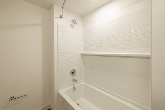 A white bathroom with a tub and shower.