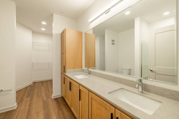 A bathroom with a sink, mirror, and wooden cabinets.