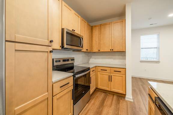 A kitchen with wooden cabinets and appliances.