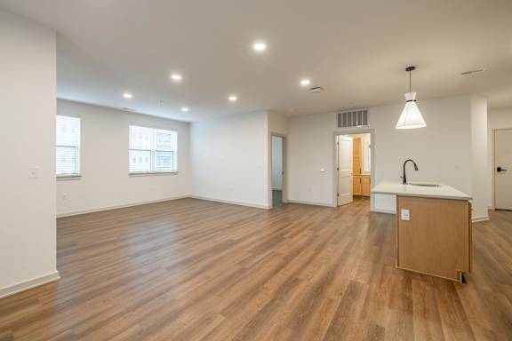A large empty room with wooden floors and white walls.