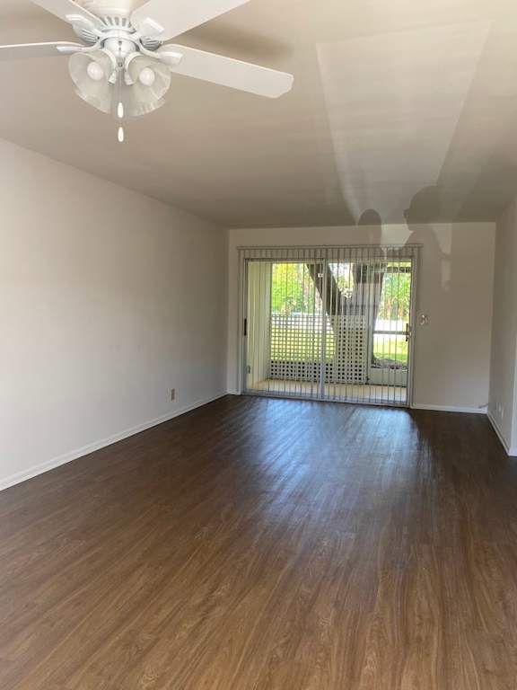 A room with a ceiling fan and wooden flooring.