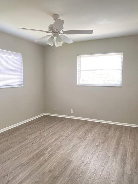 A room with a ceiling fan and a window with blinds.