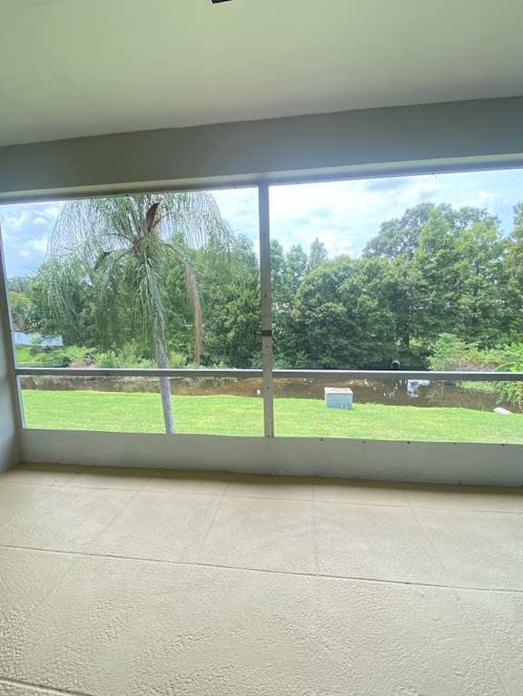 A room with a large window overlooking a green landscape.