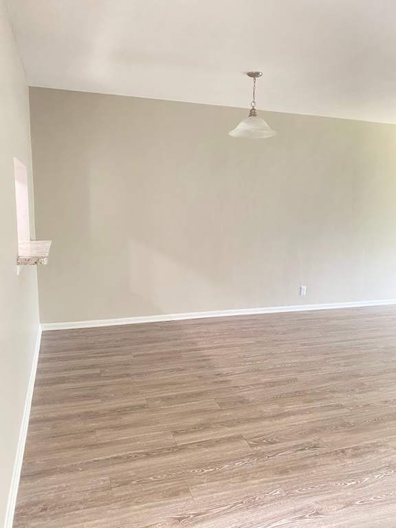 A room with a light brown floor and a white ceiling with a light fixture.