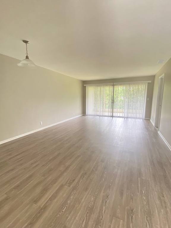 A room with wooden flooring and a hanging light fixture.