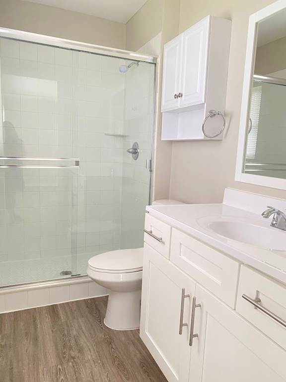 A white toilet sits in a bathroom next to a walk-in shower.