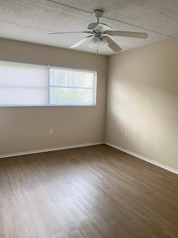 A room with a ceiling fan and a window with blinds.