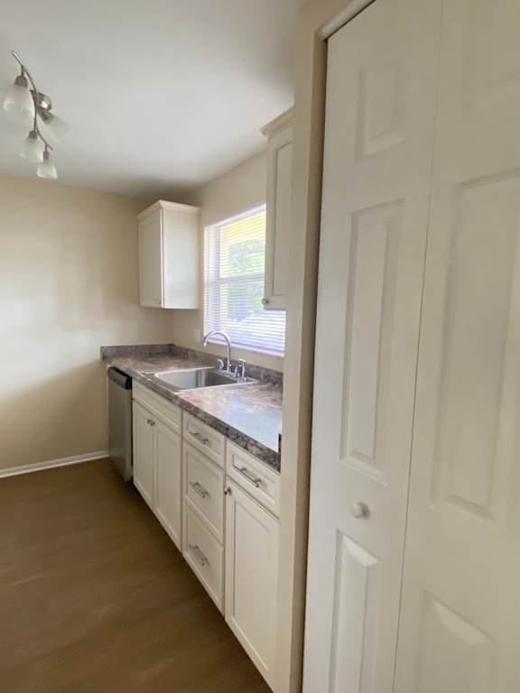 A kitchen with white cabinets and a sink.