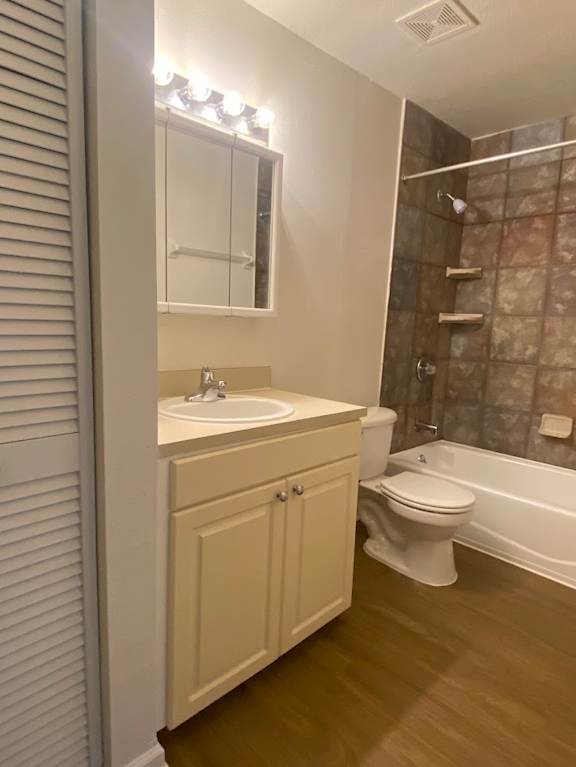 A white bathroom with a sink, toilet, and a shower.