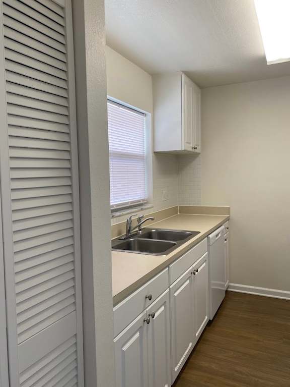 A kitchen with white cabinets and a sink.