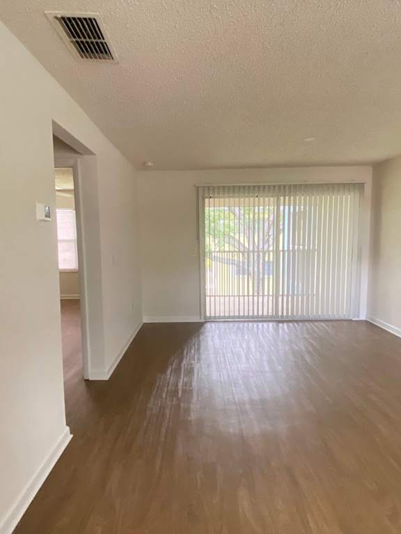 A room with wooden floors and a window with blinds.