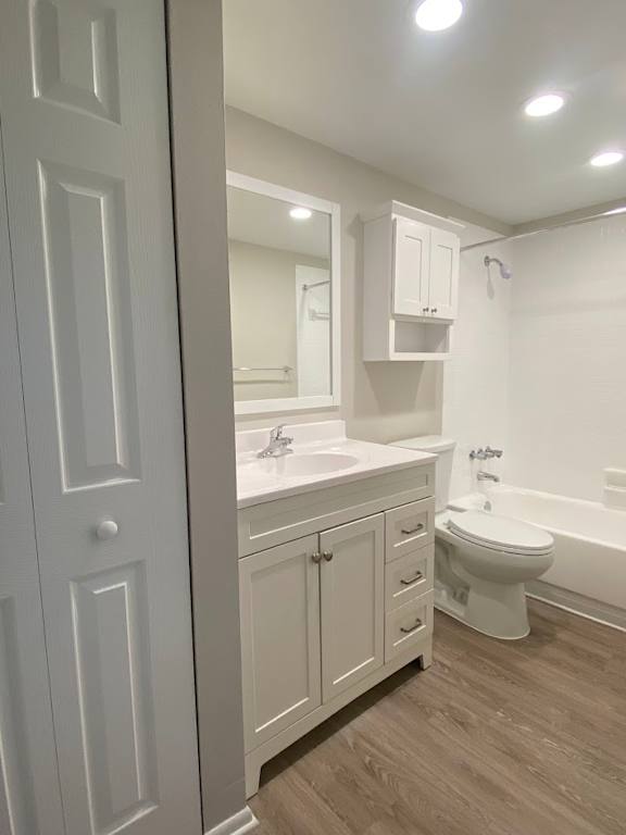 A white bathroom with a toilet, sink, and mirror.
