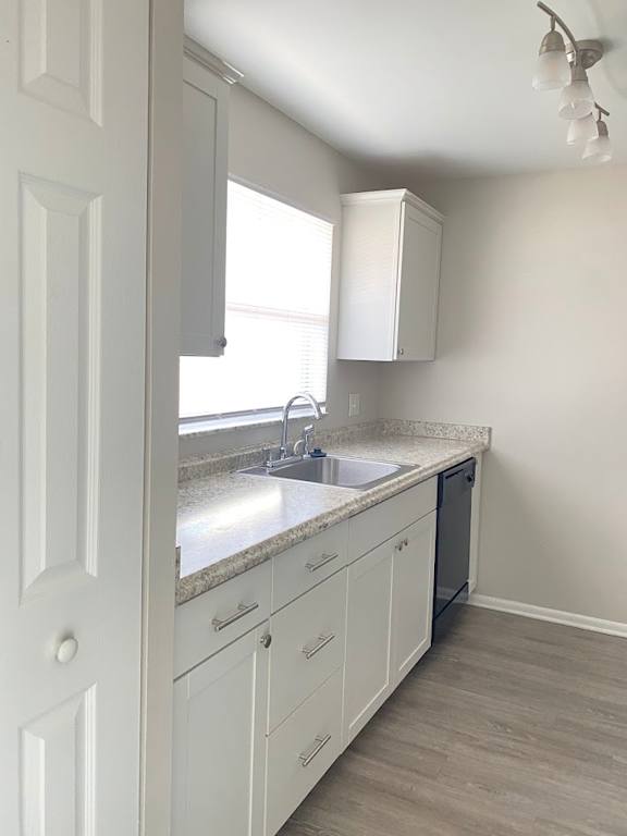 A kitchen with white cabinets and a marble countertop.