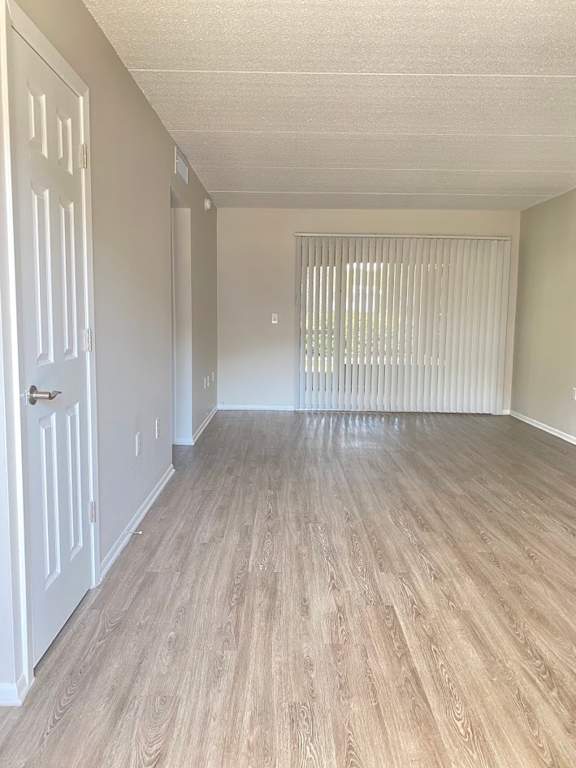 A room with a white door and wooden flooring.