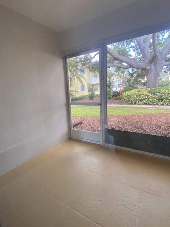 A room with a sliding glass door leading to a garden.