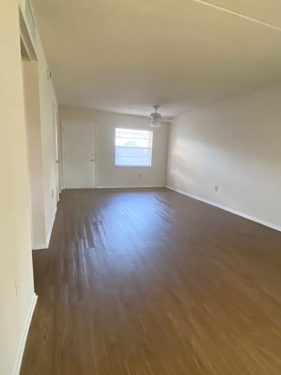 A room with wooden flooring and a window.