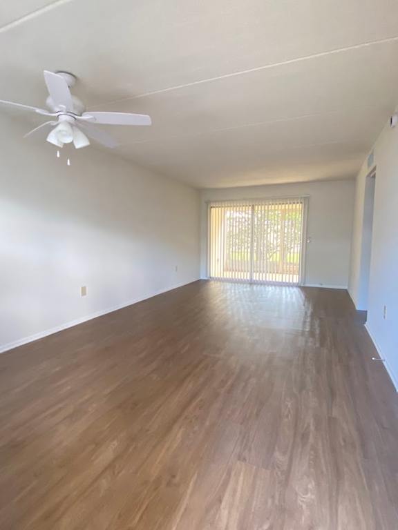 A room with a ceiling fan and wooden flooring.