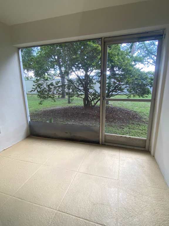 A room with a sliding glass door leading to a backyard.