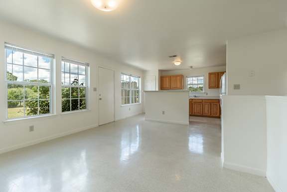 an empty living room and kitchen with large windows  at Huntington Village **, Warner Robins