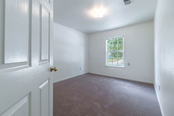 a bedroom with white walls and carpet and a window  at Huntington Village **, Georgia, 31098